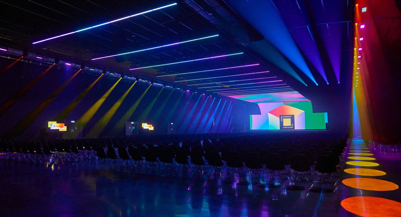 Mailchimp corporate event stage with coloured beam lighting
