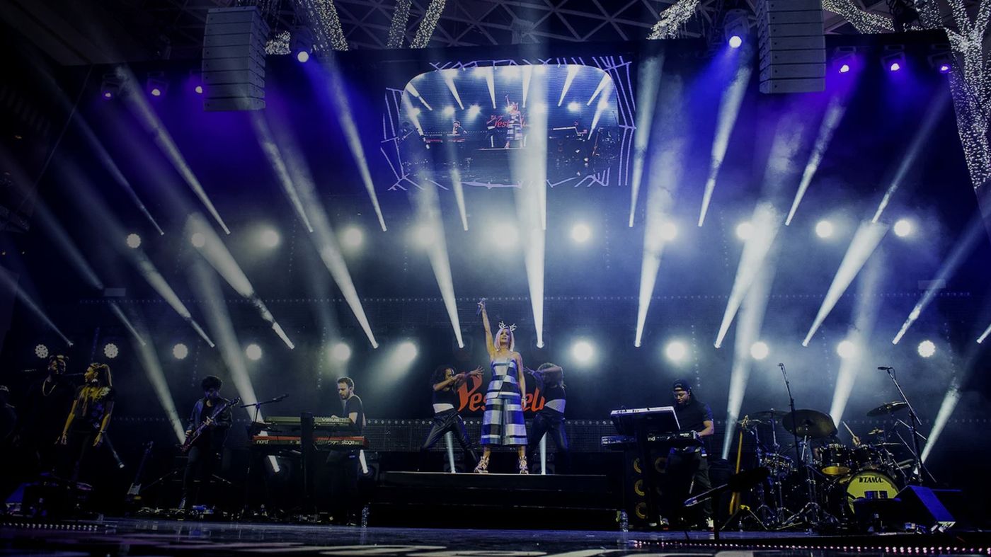 Live concert performance under a wide rig of white beams